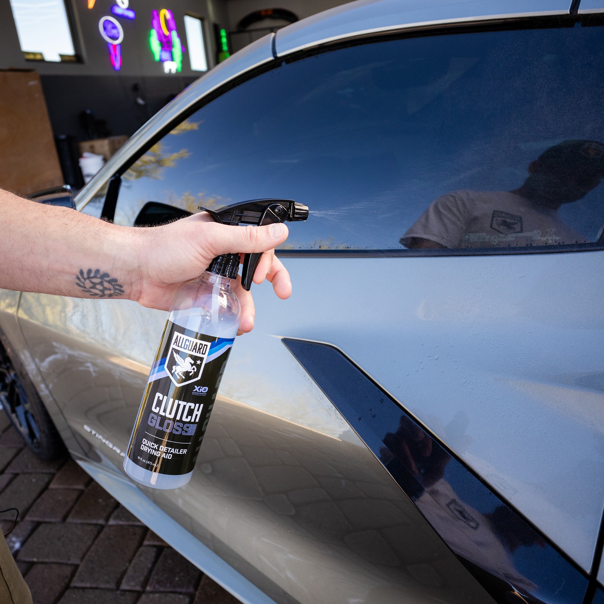 Man spraying quick detailer on driver side car door