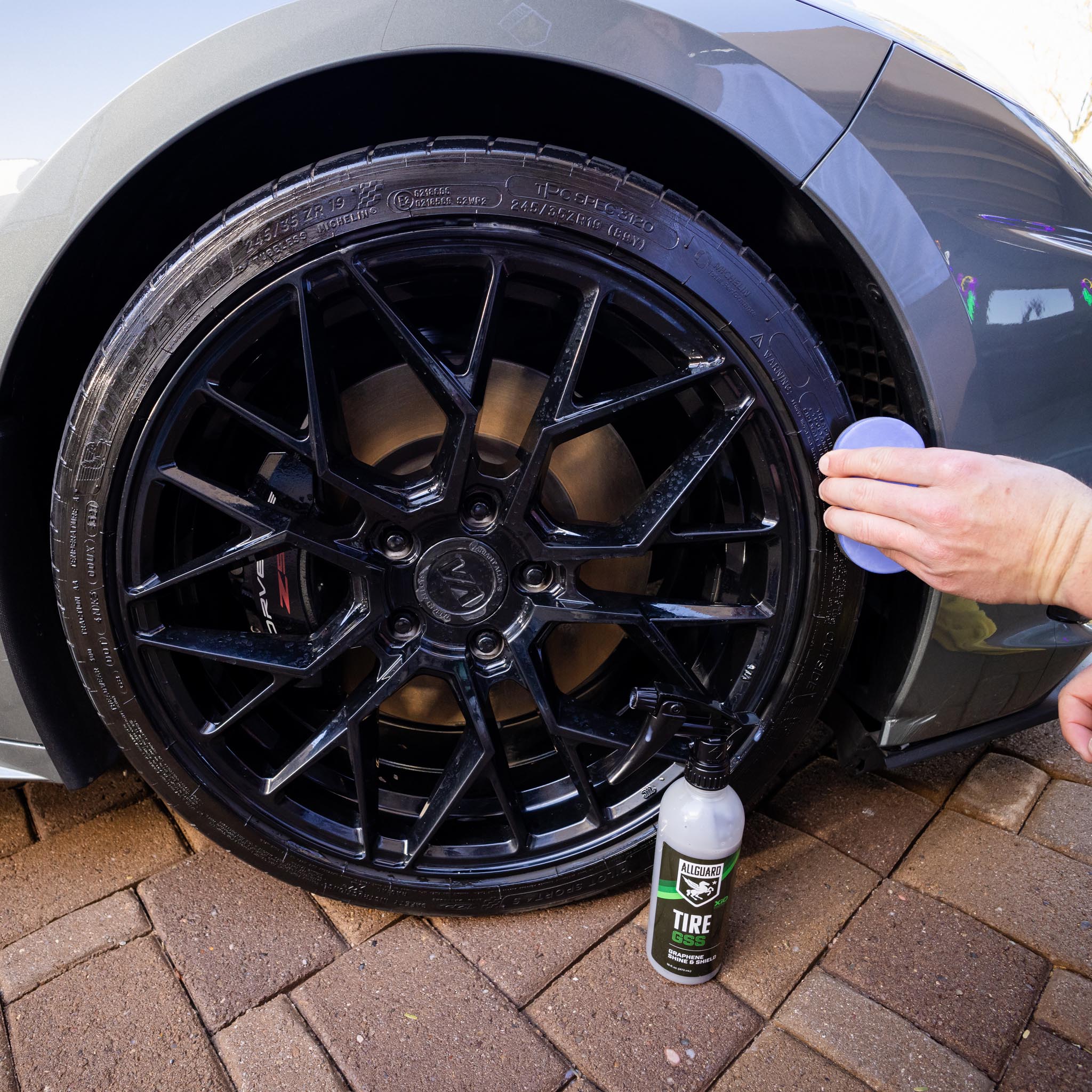 Man detailing rims and tires with Tire GSS spray