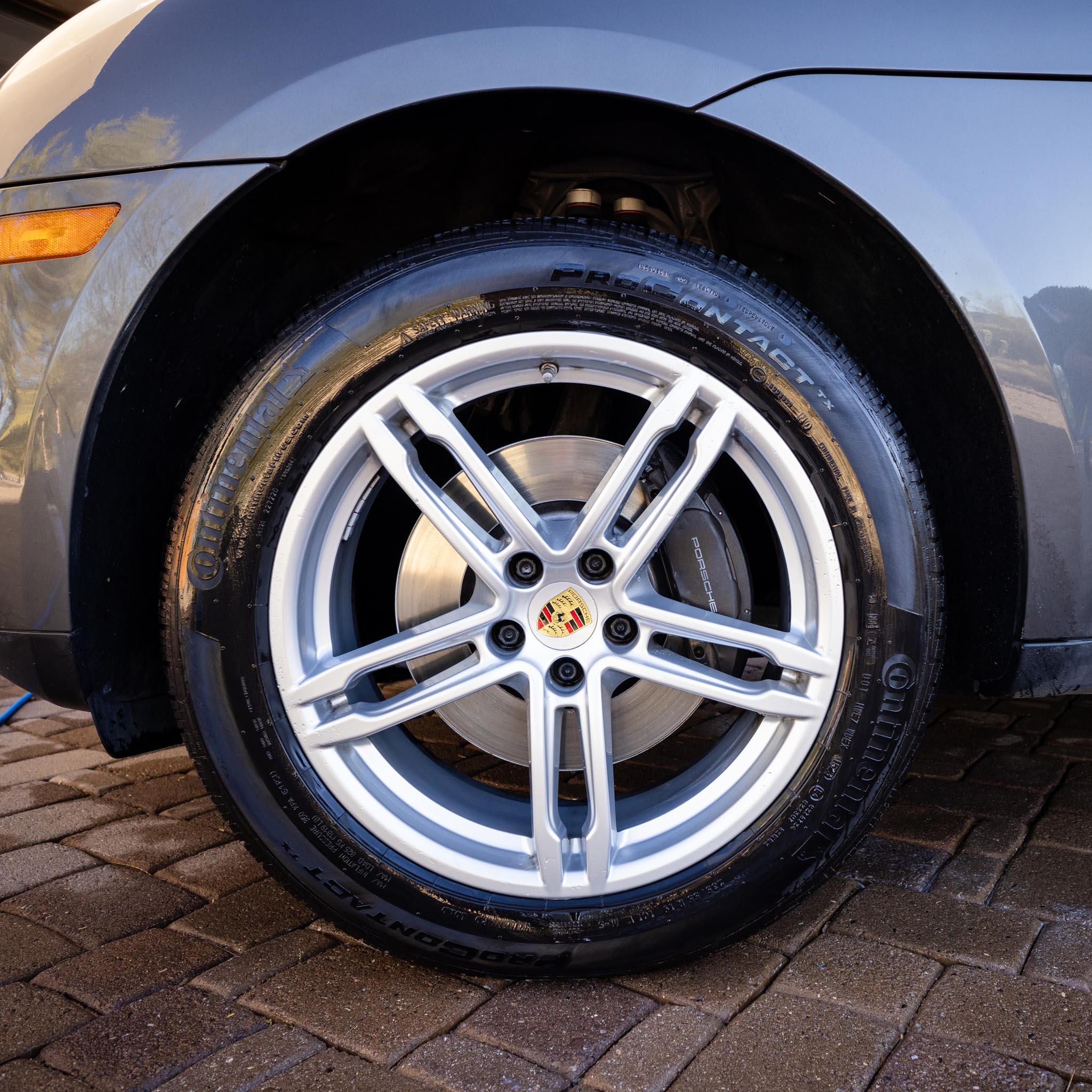 Rim and front of porsche after being detailed with ALLGUARD products