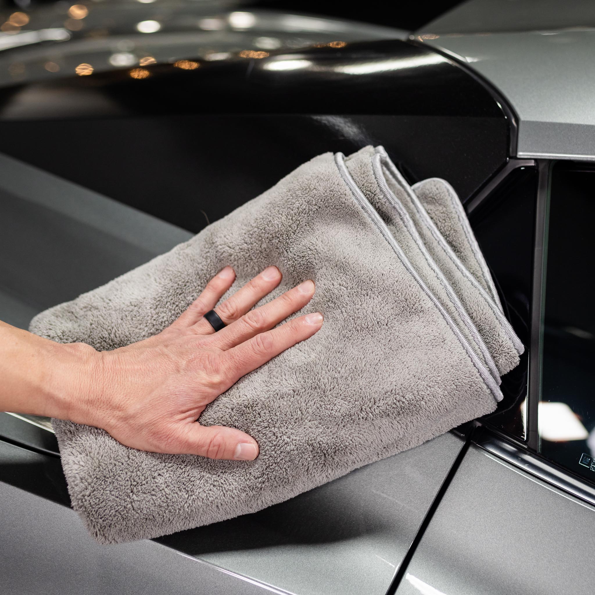 Man drying car window with quick dry towel