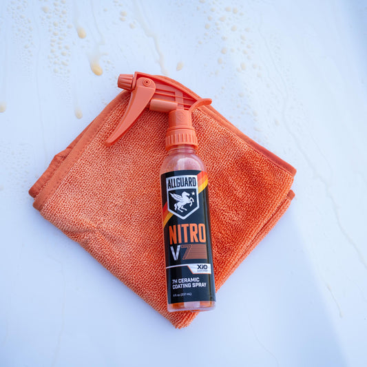 Ceramic coating spray laying on orange microfiber towel