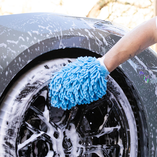Blue Velux Wash Mitt washing black rims with soapy water