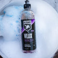 VLUX ceramic car wash soap bottle floating in bucket of water