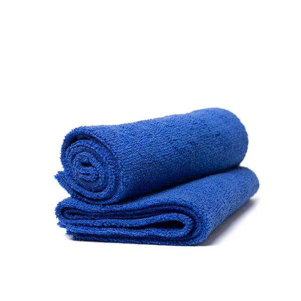 Blue microfiber car detailing towel rolled up on folded towel