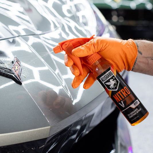 Ceramic coating being sprayed on car emblem